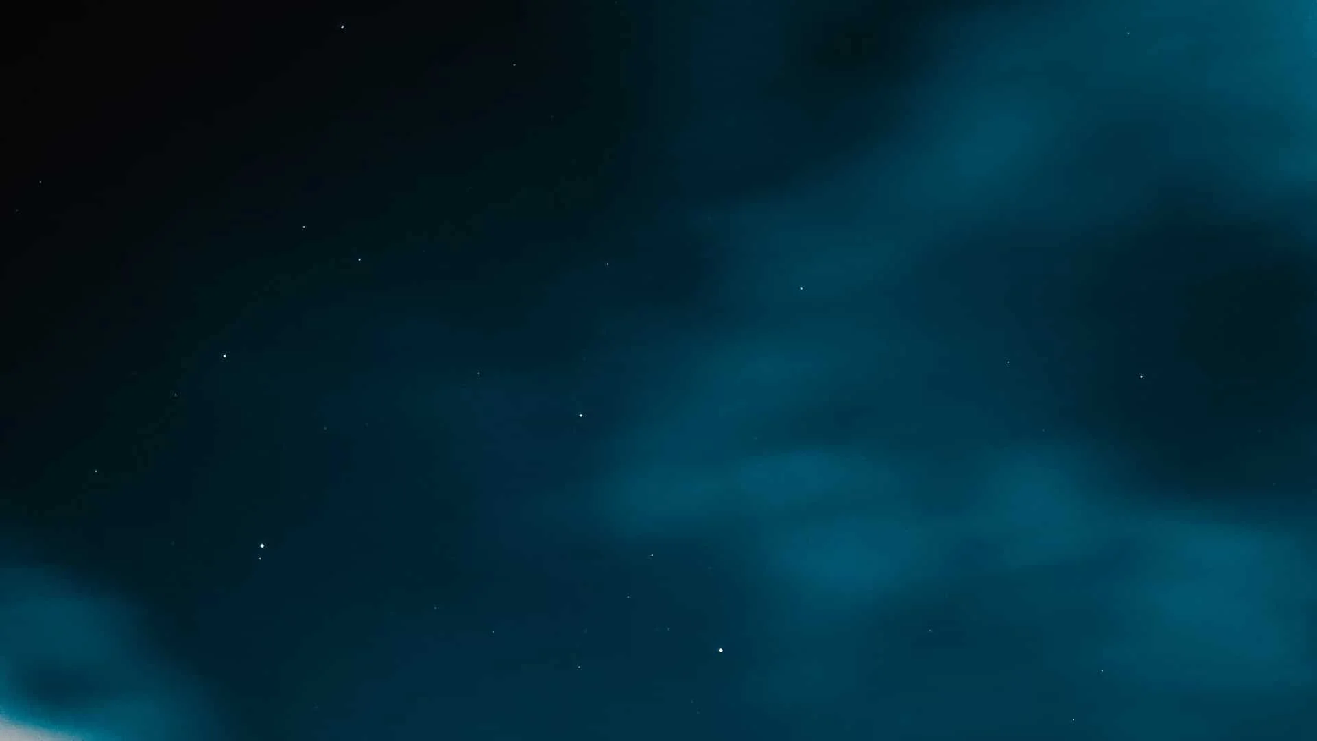 Dark night sky with faint blue clouds and scattered stars, creating a dreamy and tranquil atmosphere.